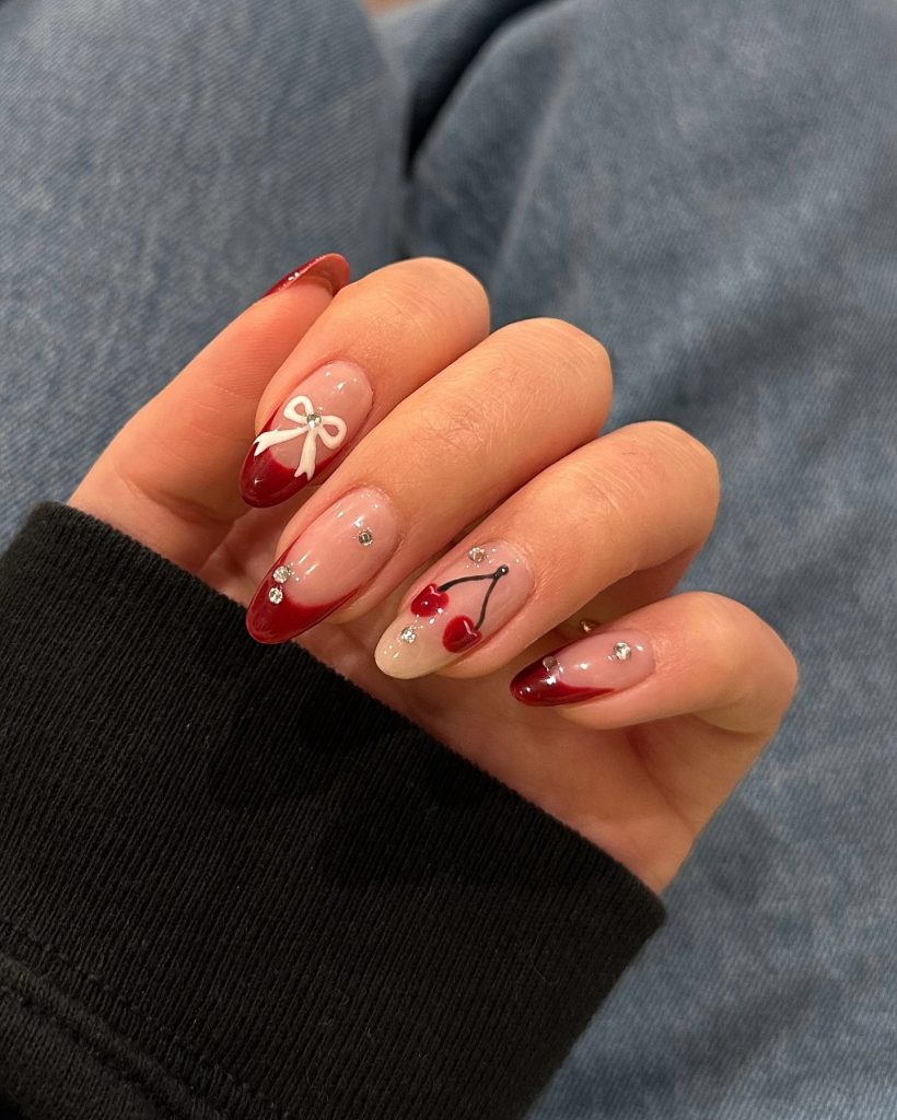 red nail with cherries and white ribbon